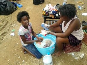 Jodi and a cousin scrubbing the dolls.