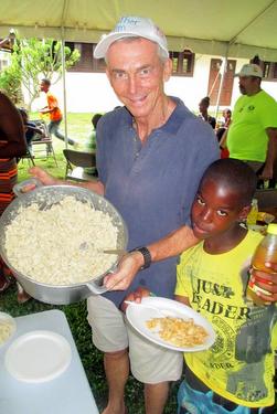 Fr. Jim Bok, OFM, serves guests at an outdoor picnic